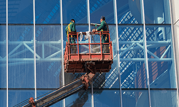 Facility Management: Workers on Scaffolding Inspecting and Maintaining Building